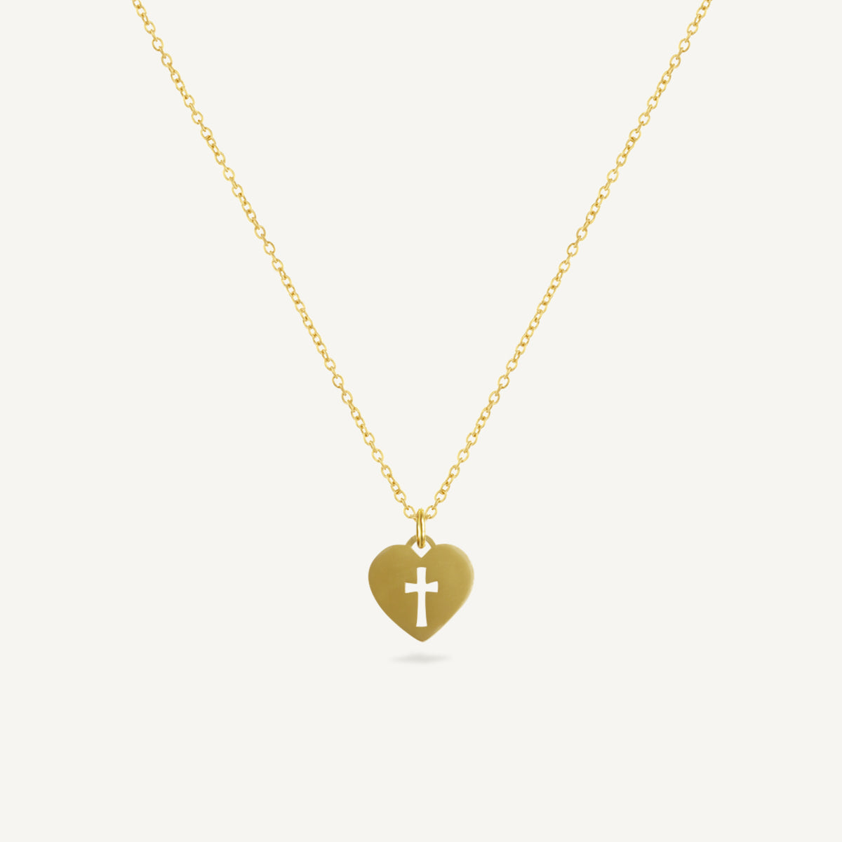 Gold necklace with a heart-shaped pendant featuring a cross on a white background