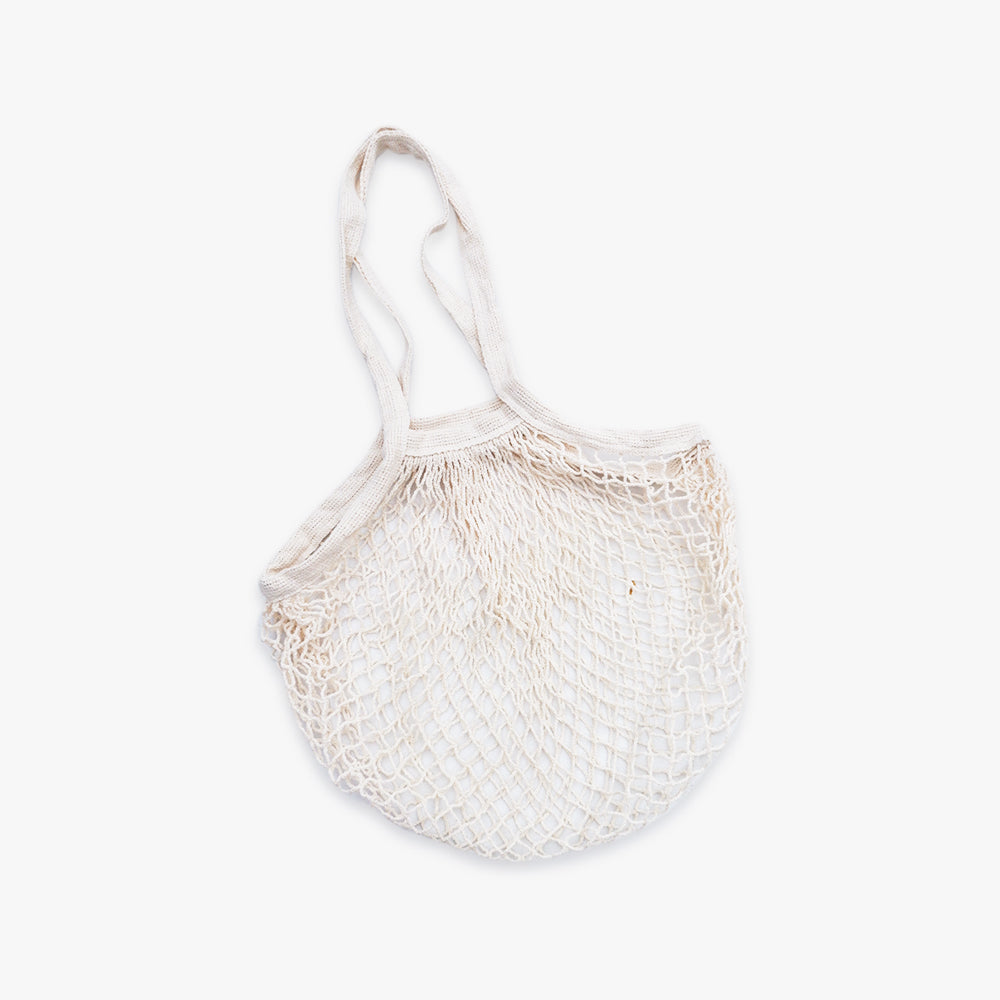 A beige, netted French market bag on a white background.